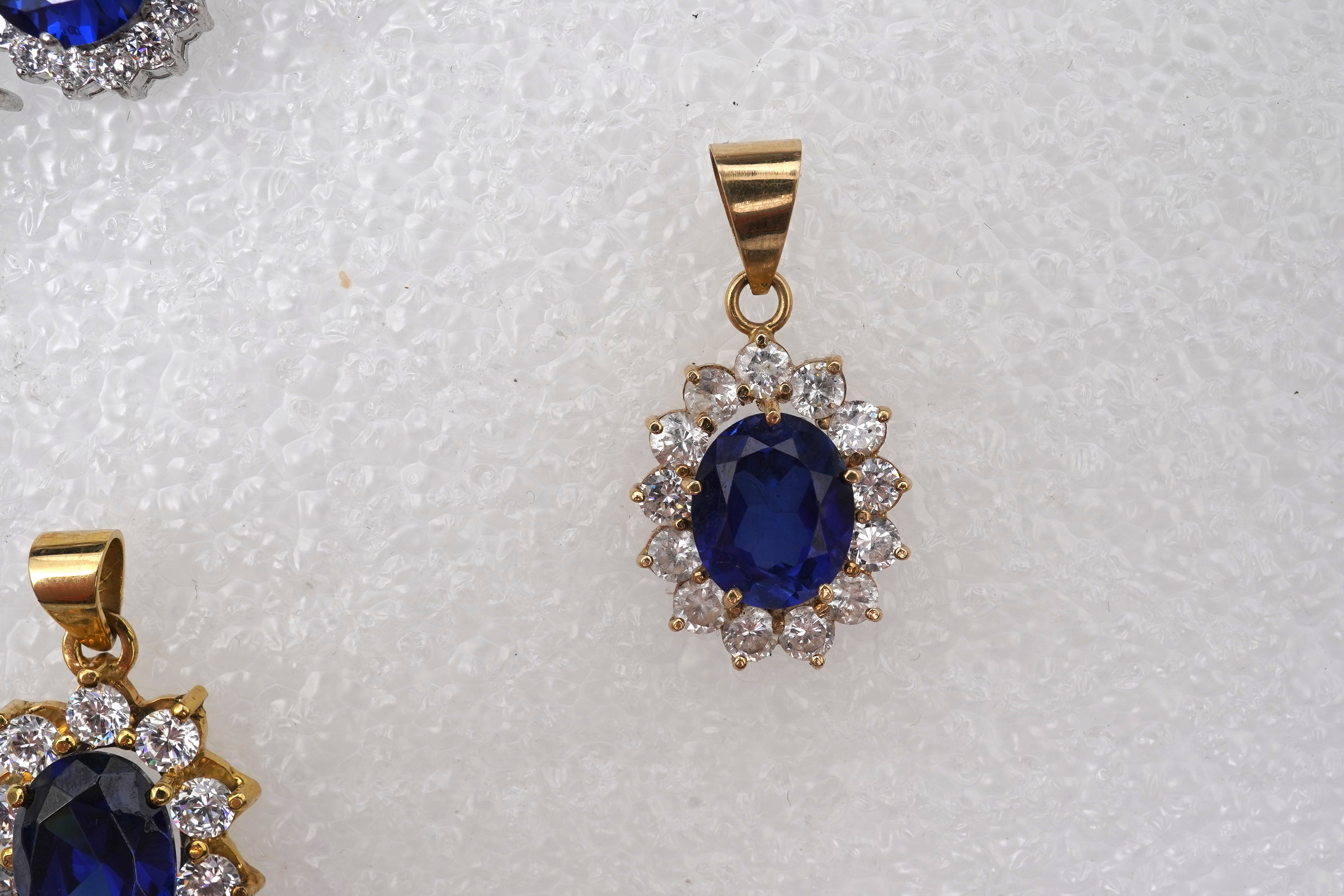 A synthetic sapphire and cubic zirconia necklace and two pendants, the necklace set with oval synthetic sapphires and brilliant-cut and marquise-shaped cubic zirconias, mounted in silver, length 44cm, stamped 925; togeth